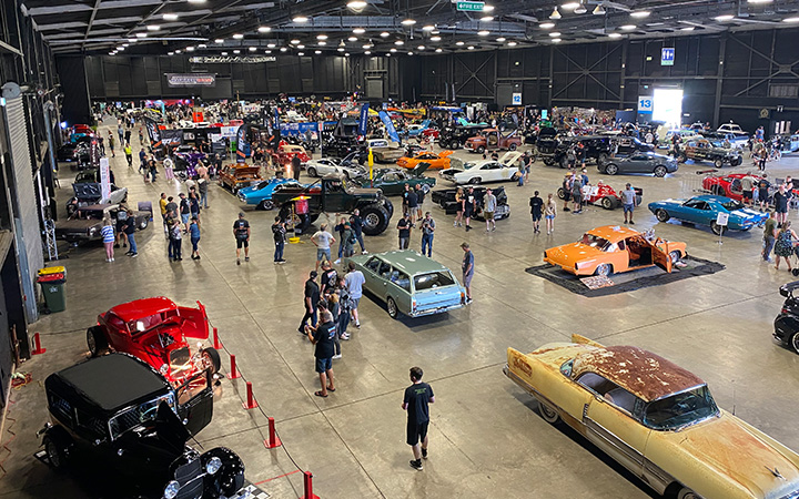 A crowd of people gathered at Autorama Industry Show, admiring the various vehicles on display.