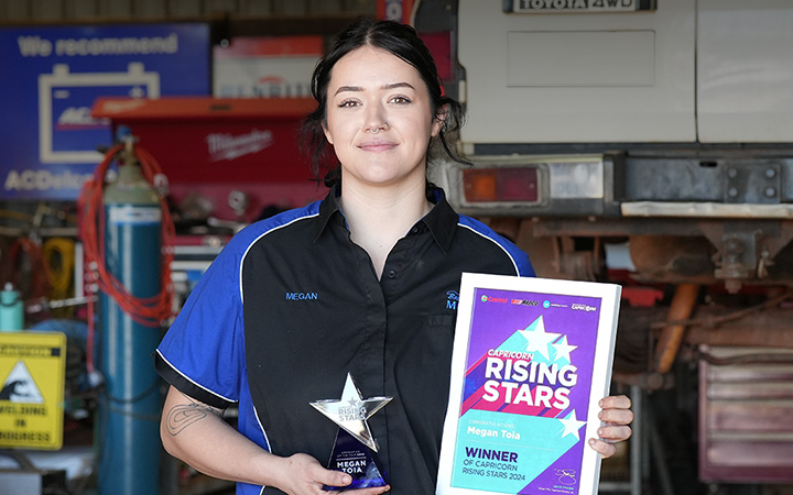 Megan Toia, the 2024 Capricorn Rising Stars Overall Winner, smiles while holding flowers, a certificate and trophy that reads "Capricorn Rising Stars Certificate Mega Toia Winner."