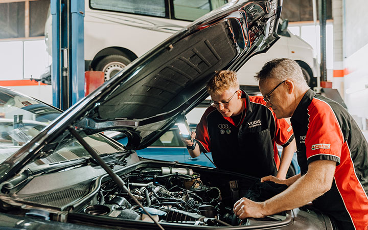 Two men looking at car