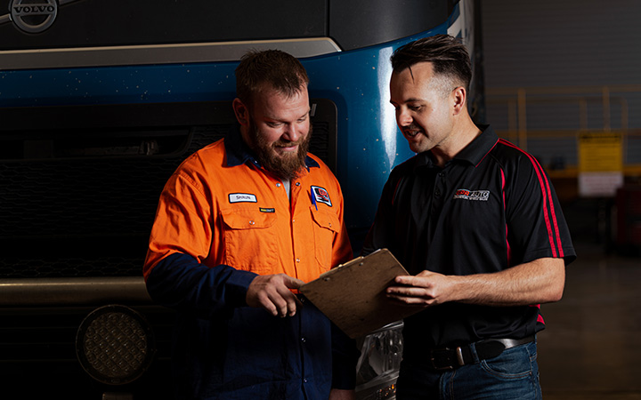 Two people holding a paper and looking the information