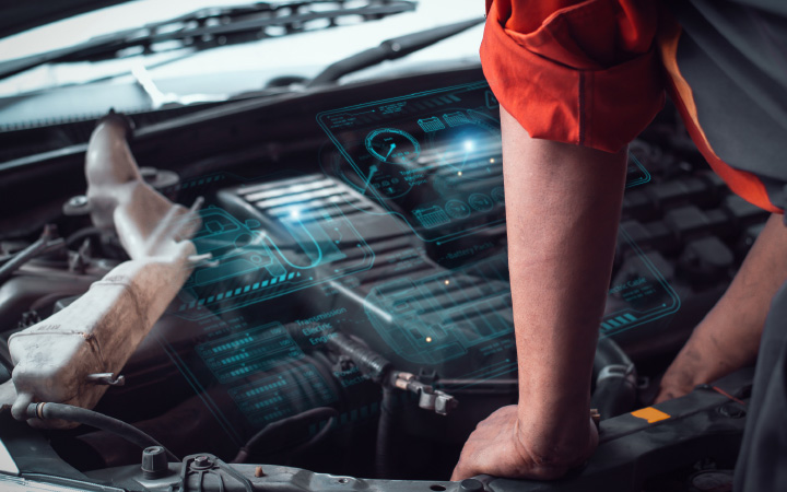 Technician using AI‑powered diagnostics on a vehicle with the bonnet up, digital data overlay guiding fault‑finding in an aftermarket workshop.