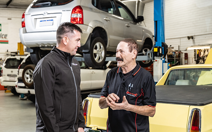 Capricorn consultant talking with an workshop owner in his garage