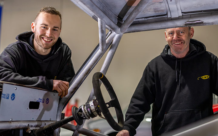 Two people working on car