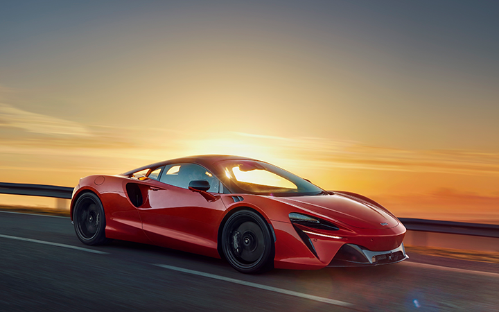 Mclaren Artura being driven at the sunset