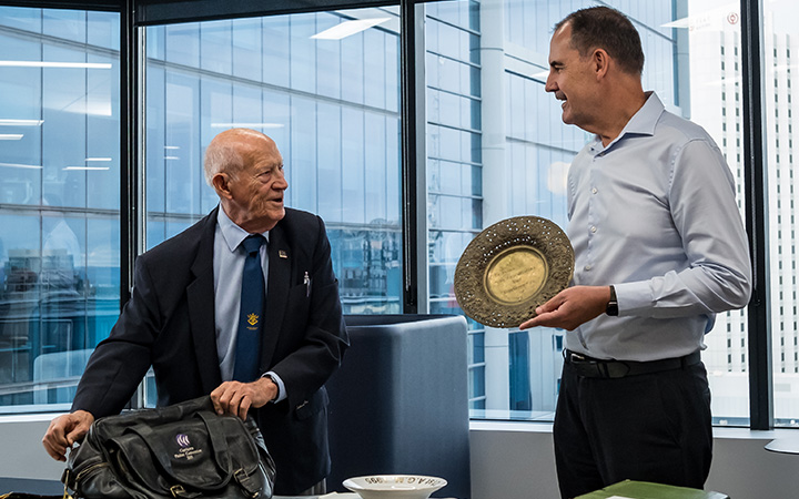 Frank and David looking at each other while checking some Capricorn items from the past