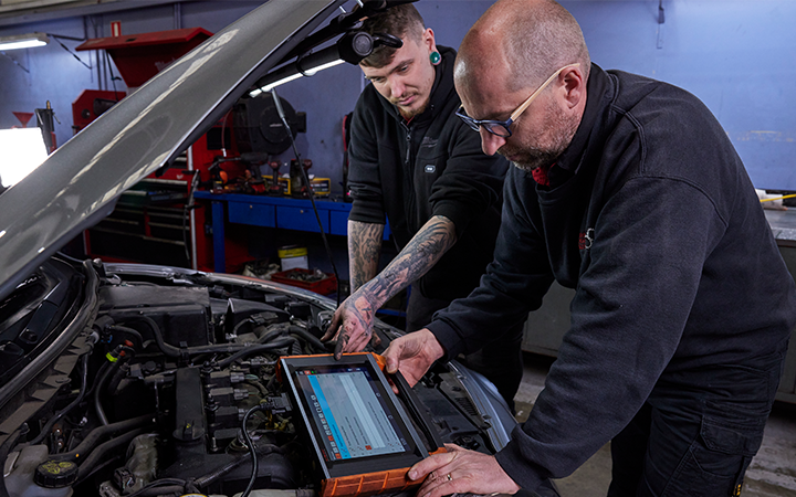 Mechanics using an electronic diagnostic tool in a vehicle
