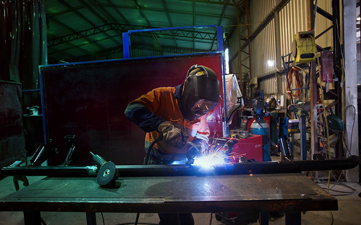 A skilled person welding in a workshop, creating sparks as they work