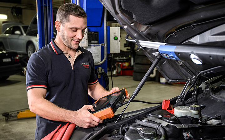 Mechanic using a car diagnostic tester