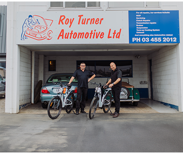 Roy Turner and a Capricorn Area Manager standing next to the e-bikes outside the front of the Roy Turner Automotive building.