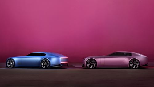 A blue Jaguar Type 00 car and a pink Jaguar Type 00 car against a pink background.