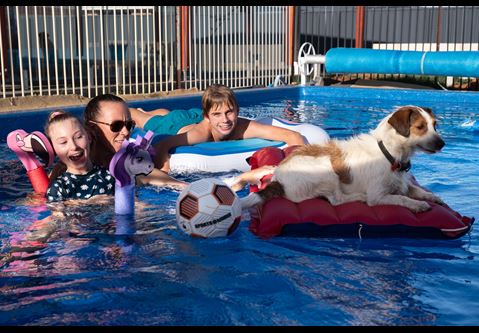 Pippa Funneman, her brother and mother and their dog playing in the pool