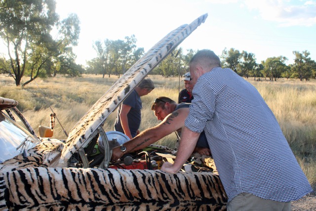 People working on car engine