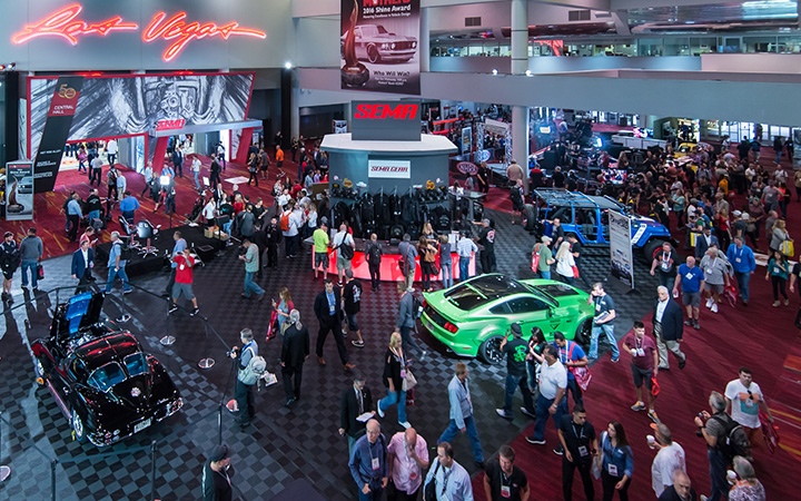 A bustling crowd gathers at the SEMA Show, showcasing a vibrant atmosphere filled with automotive enthusiasts and industry professionals.