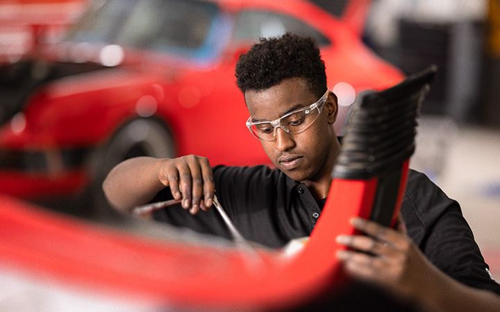 A vehicle is being repaired by a mechanic.
