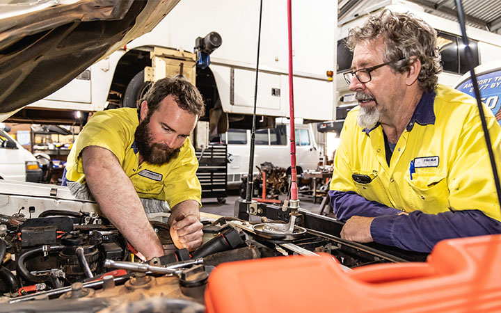 Two men over engine