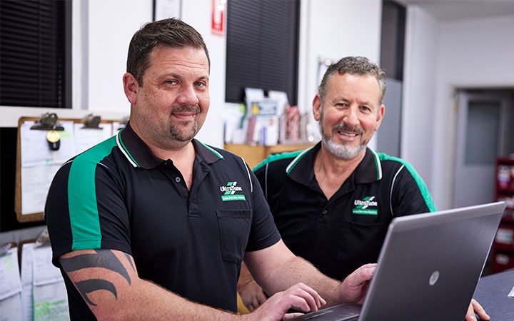 Two men in front of laptop