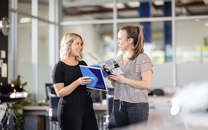 Capricorn's Risk Area Manager showing a brochure to a business owner