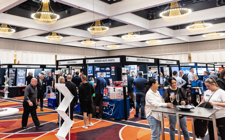 An energetic tradeshow bustling with attendees exploring numerous exhibition stands, creating a dynamic atmosphere of business and networking.