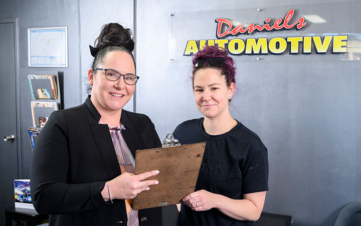 Two women in front of sign