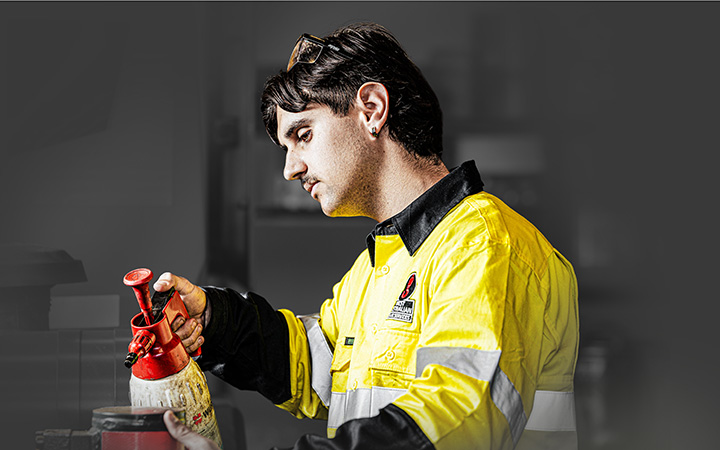 A mechanic in a yellow shirt working