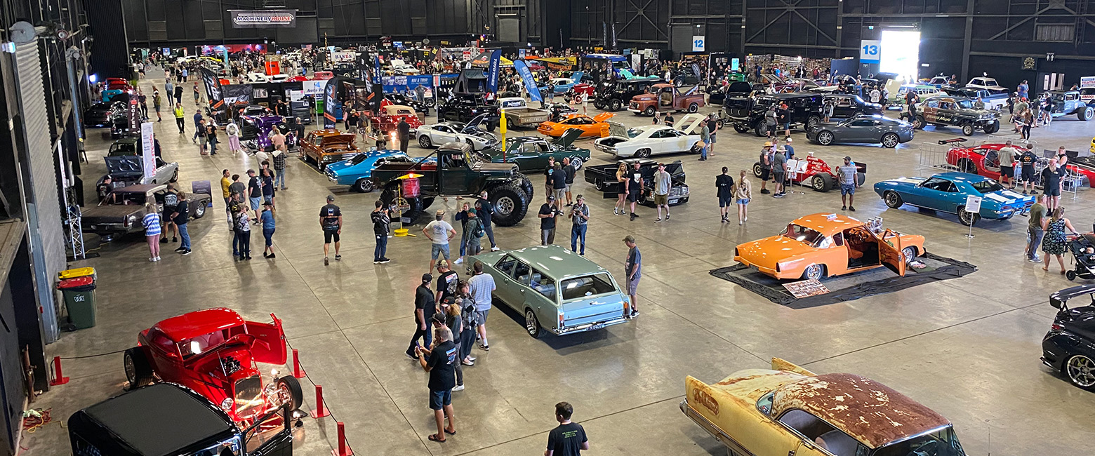 A crowd of people gathered at Autorama Industry Show, admiring the various vehicles on display.