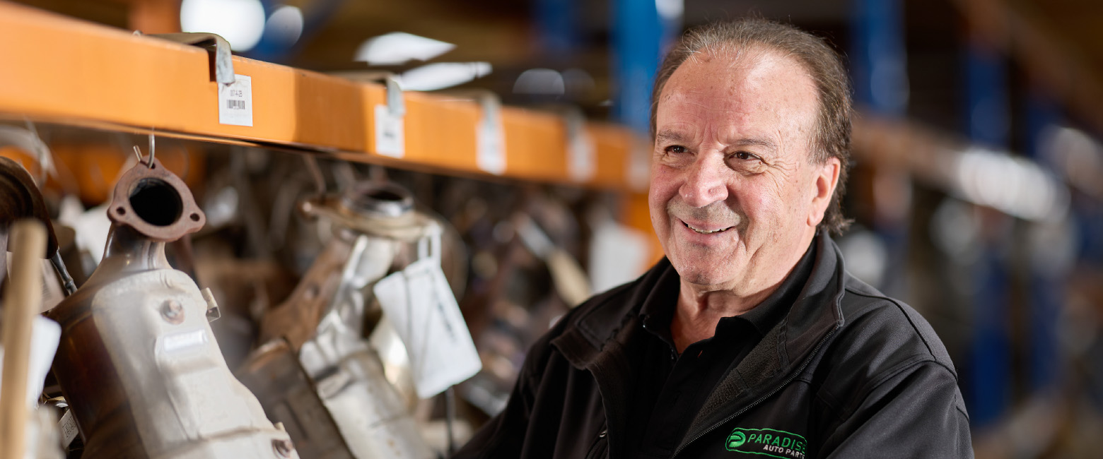 Capricorn Member at Paradise Auto Parts inspecting tagged automotive components in a well-stocked warehouse