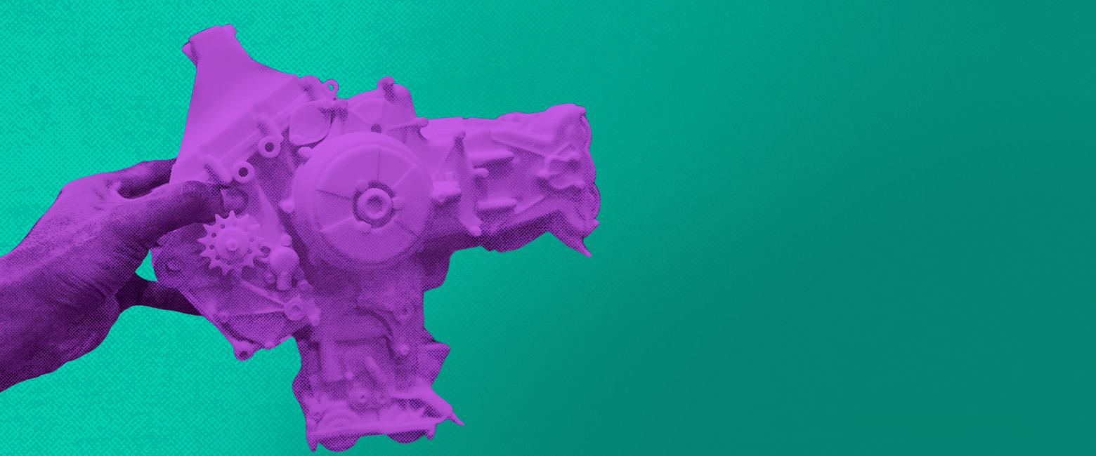 A hand holding an auto part created through 3D printing.