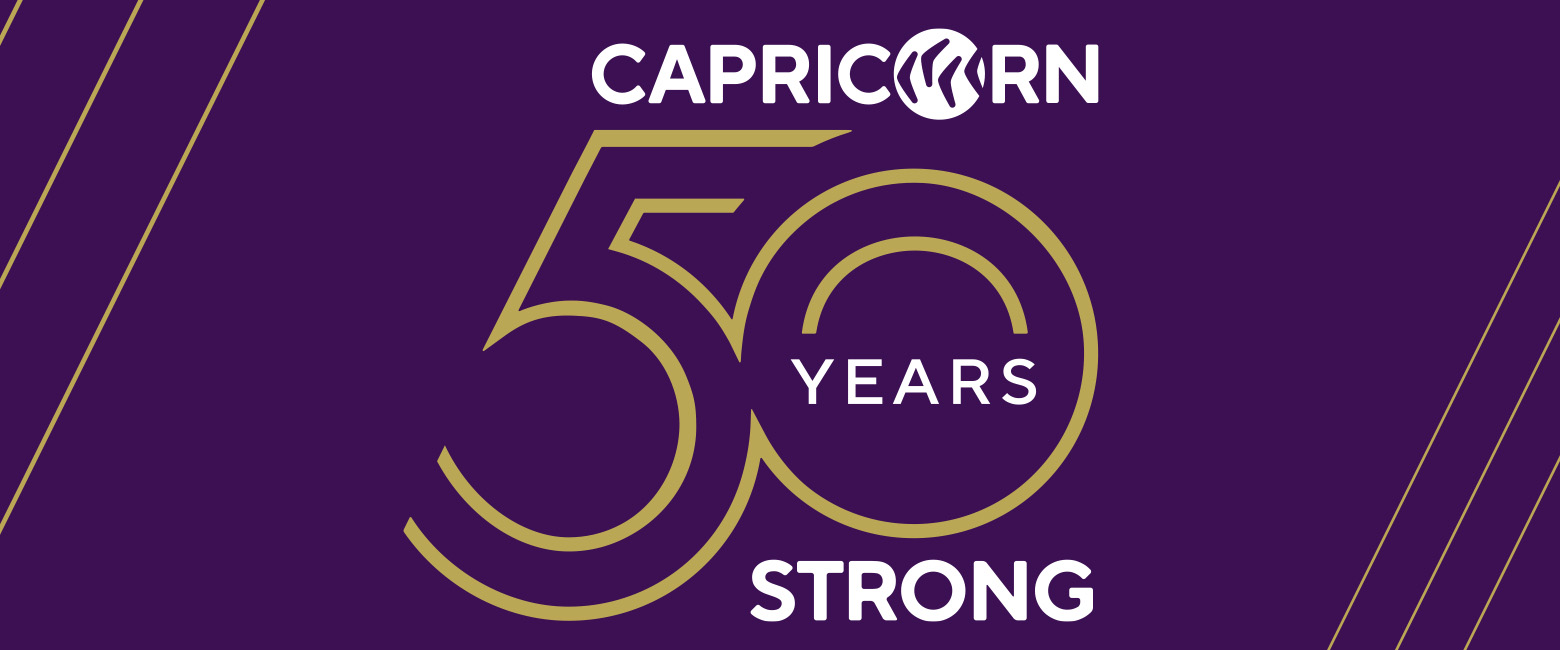 Capricorn 50 Years Strong logo with purple background and gold outline