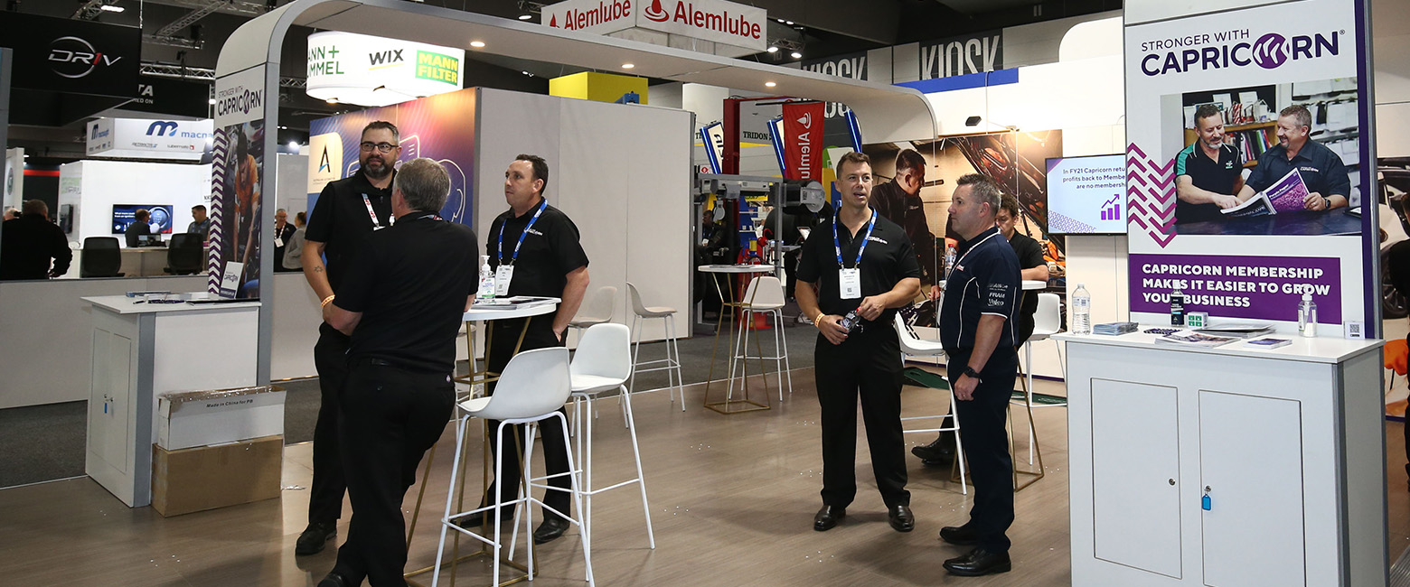 A large display at AAAExpo attracts a group of people, with Capricorn proudly standing amidst the crowd.