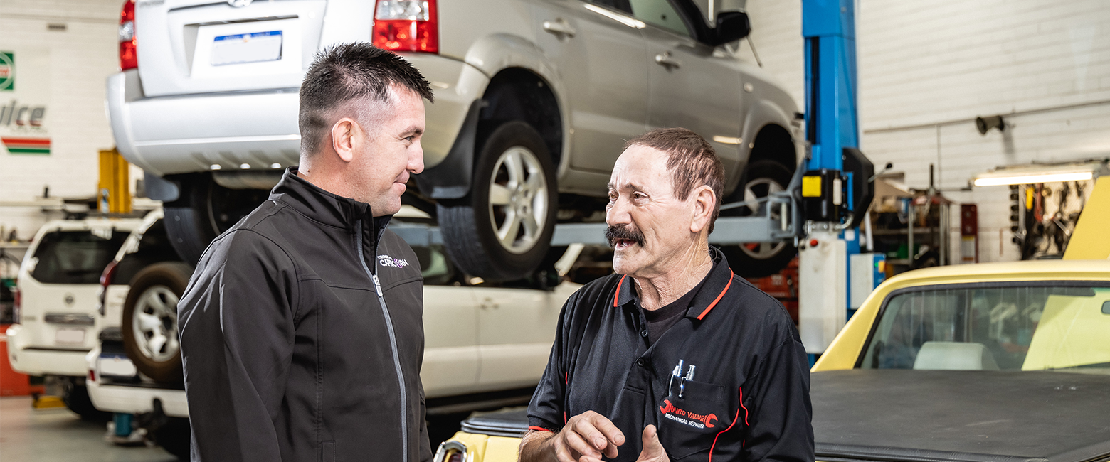Capricorn consultant talking with an workshop owner in his garage