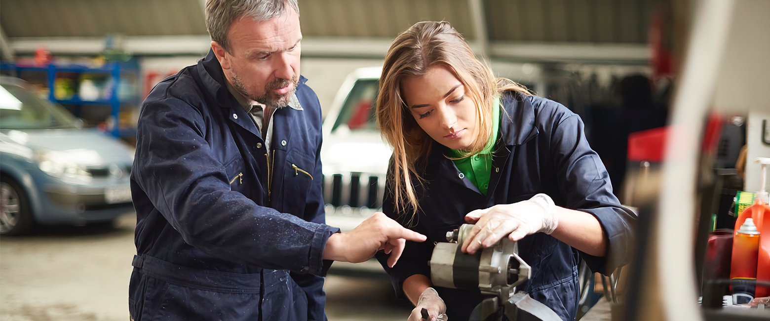 Experienced mechanic training an apprentice