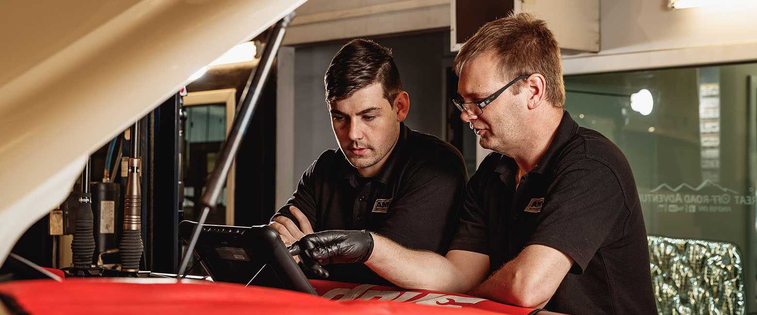 People looking at car engine