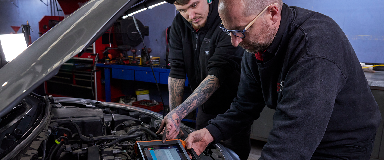 Mechanics using an electronic diagnostic tool in a vehicle