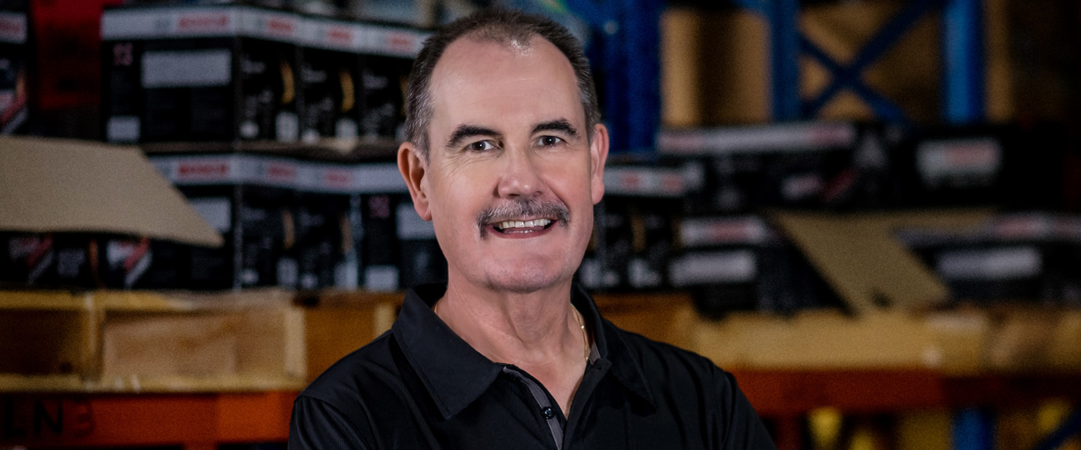 David Fraser, Capricorn Group CEO, wearing a black polo with the Capricorn logo, smiling confidently, reflecting his leadership and career legacy.