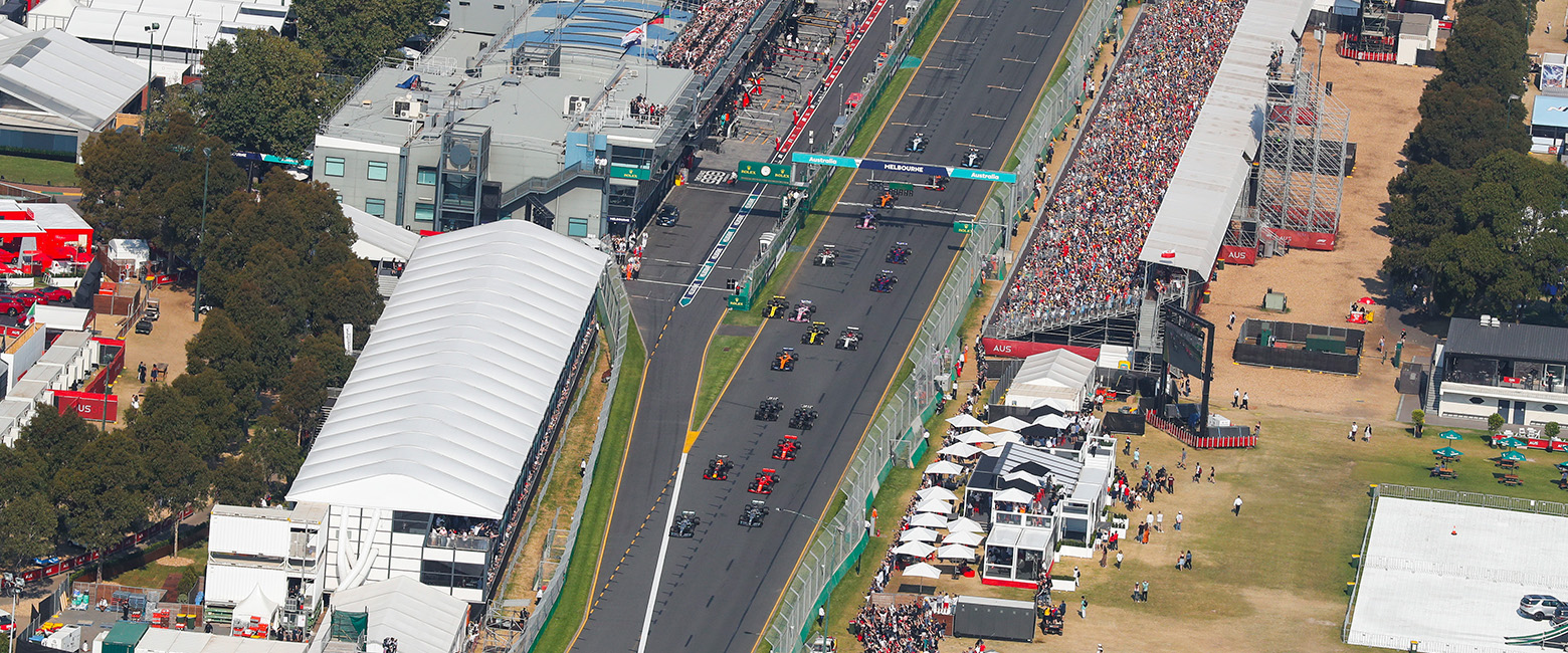 Aerial view of a city with a lake and a road, showcasing the Albert Park Circuit.