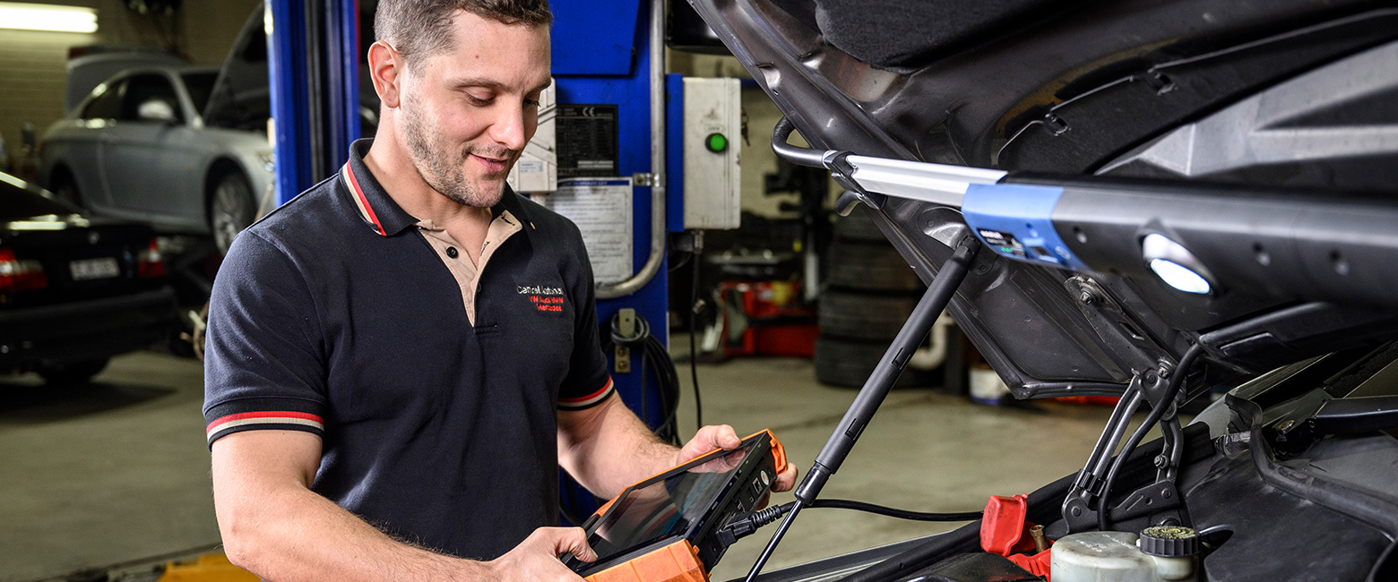 Mechanic using a car diagnostic tester