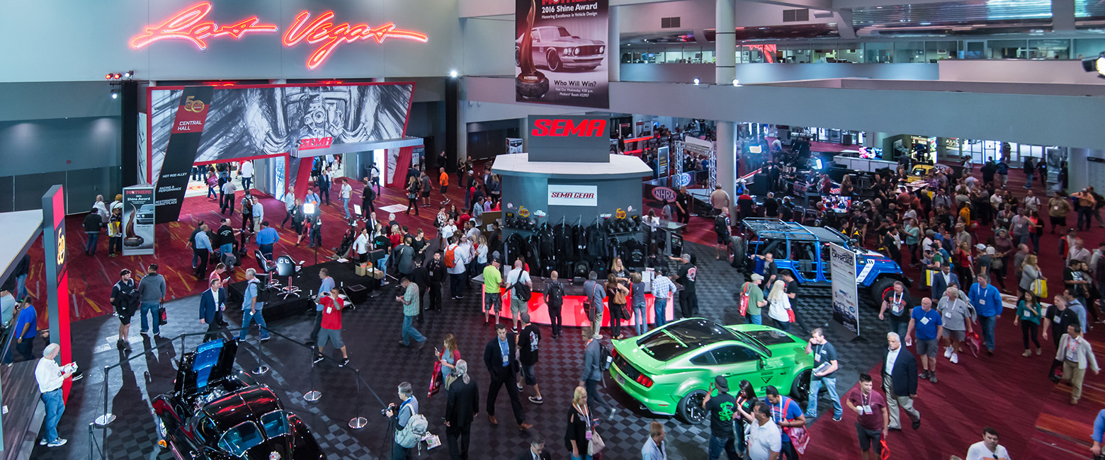 A bustling crowd gathers at the SEMA Show, showcasing a vibrant atmosphere filled with automotive enthusiasts and industry professionals.