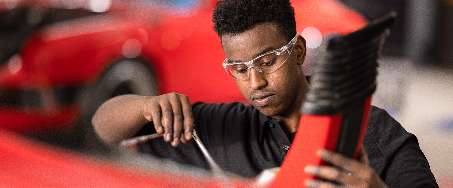 A vehicle is being repaired by a mechanic.