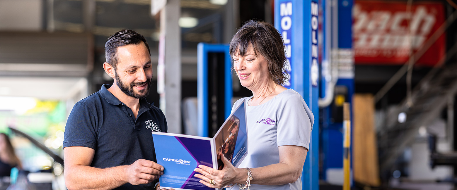 A Capricorn Member and Risk Account manager standing in a workshop