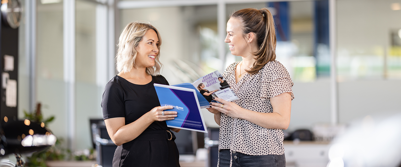 Capricorn's Risk Area Manager showing a brochure to a business owner