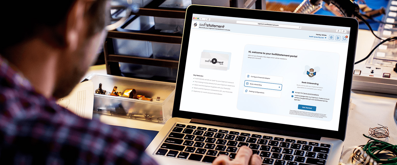 A person using a laptop displaying the SwiftStatement log in page