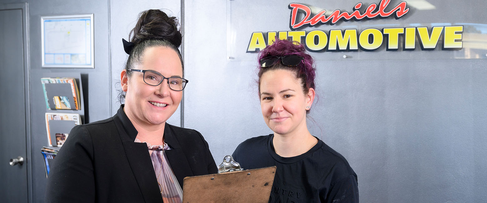 Two women in front of sign