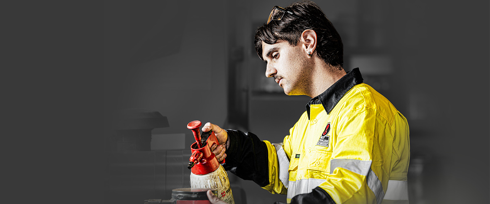 A mechanic in a yellow shirt working