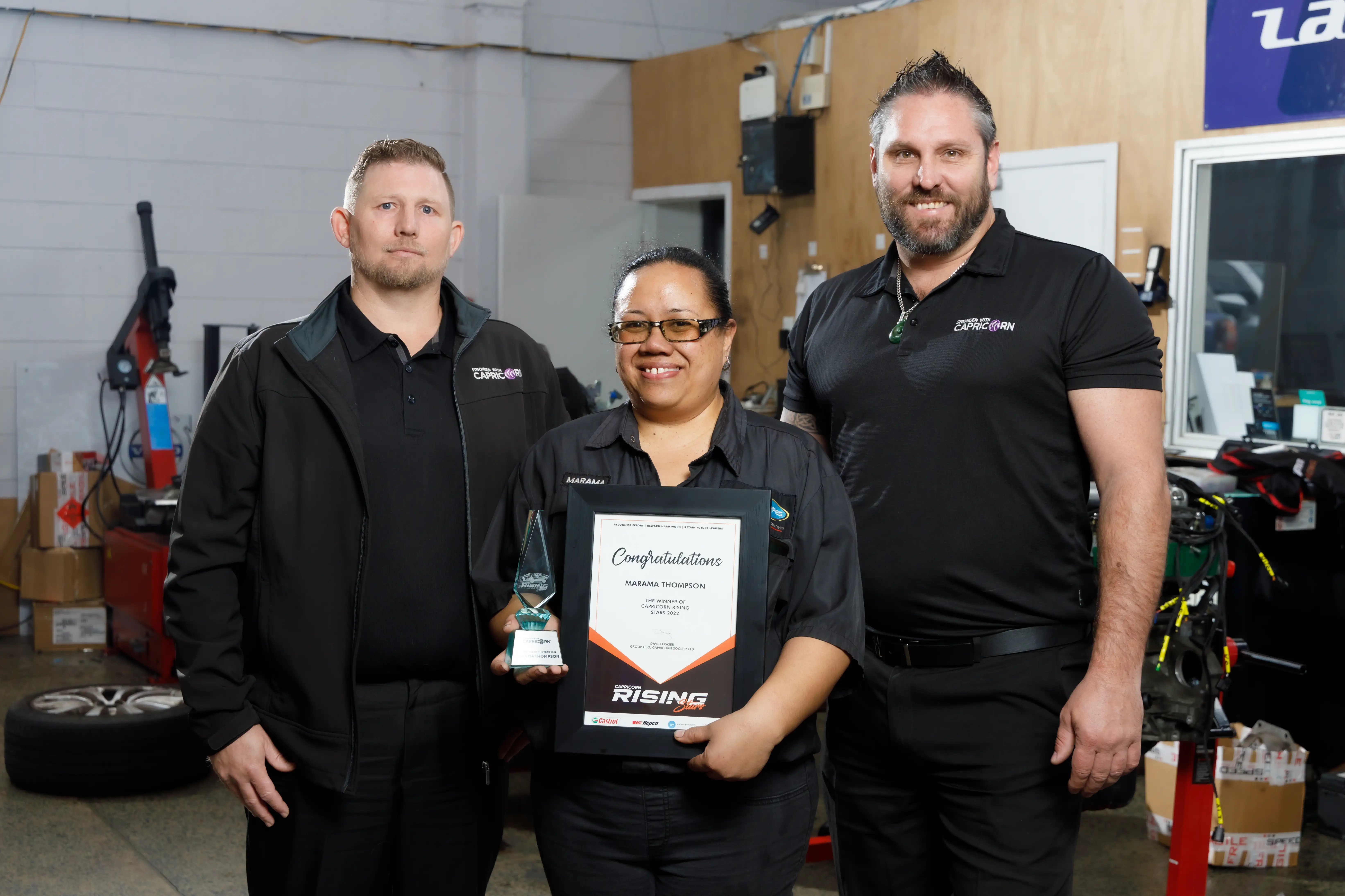 Marama Thompson holding her 2022 Capricorn Rising Stars Apprentice of the Year certificate and trophy with Mark Waller on the left side and Michael Stocks on the right side smiling at the camera