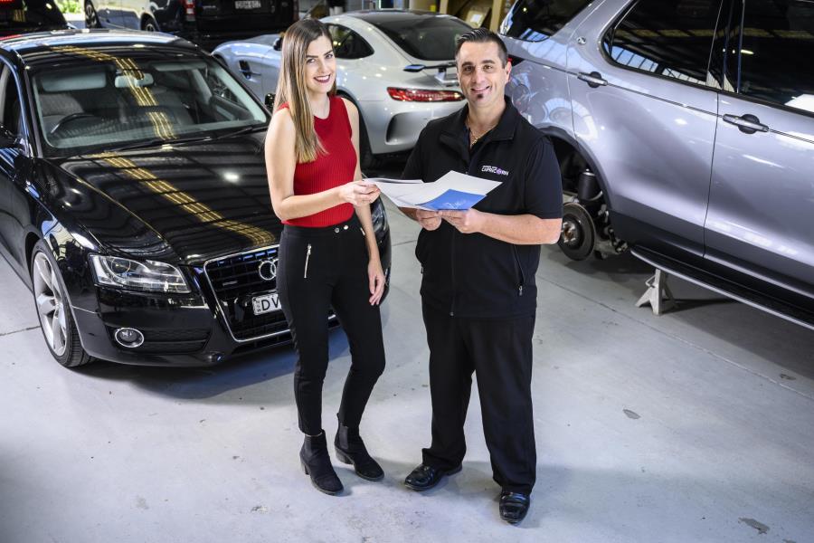 Two people in front of cars