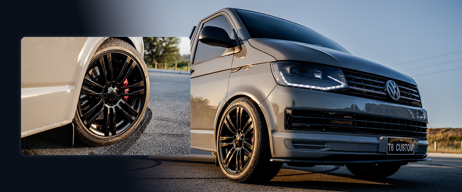 A Volkswagen Transporter facing forward, featuring stylish black wheels.