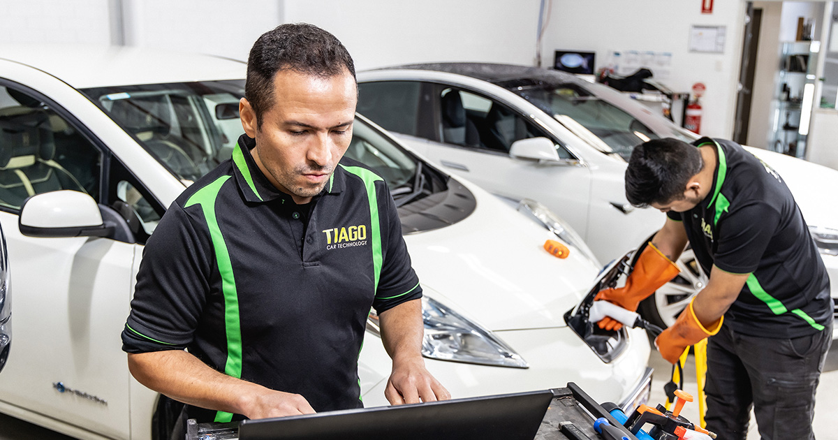 Two mechanics working on an electric vehicle