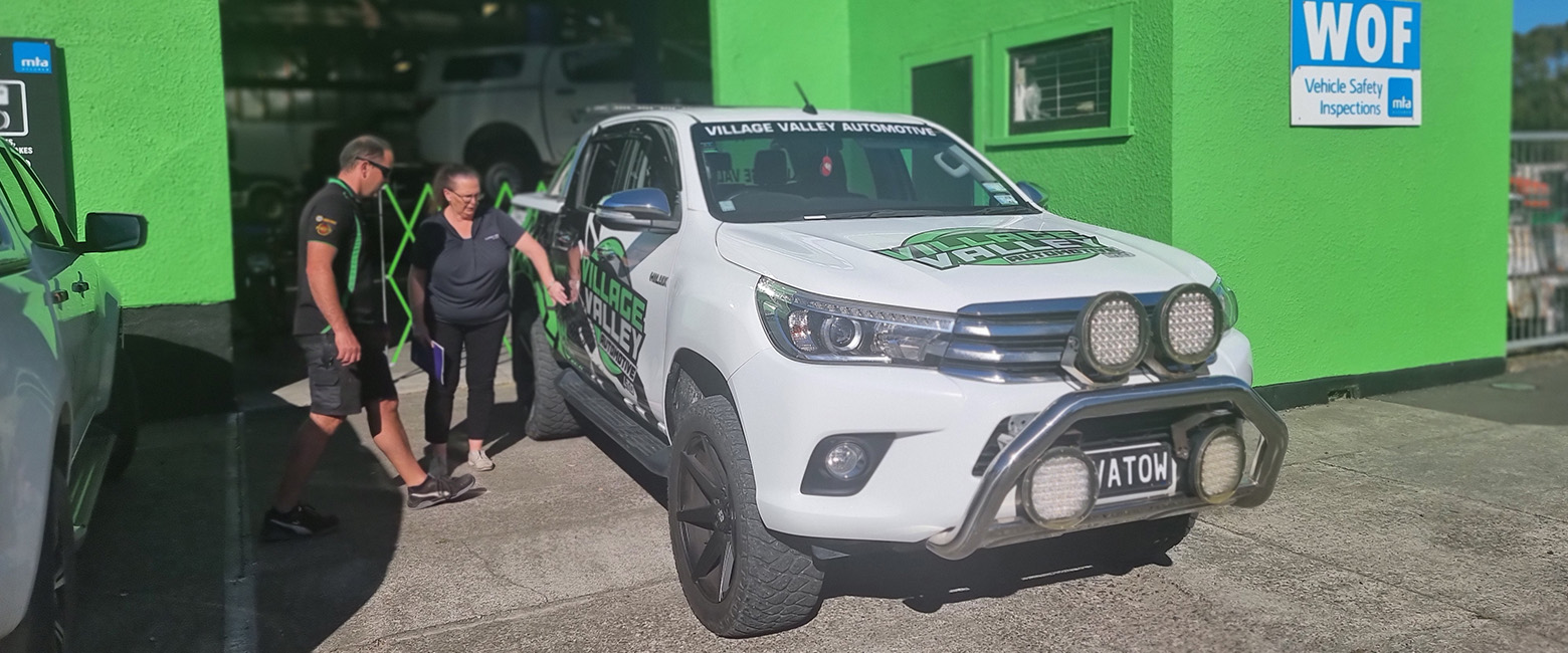 A Capricorn Member and Risk Account Manager standing beside a white truck in front the workshop.