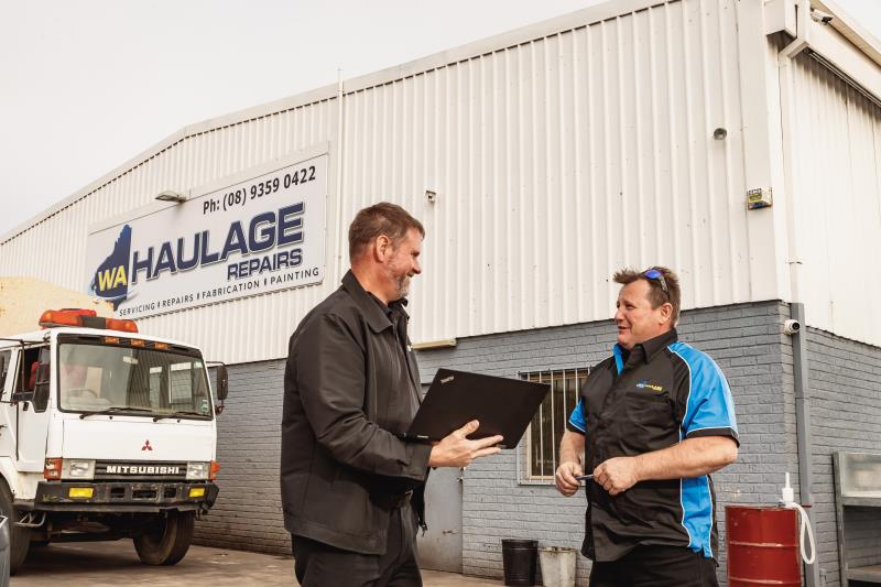 Two men in front of warehouse