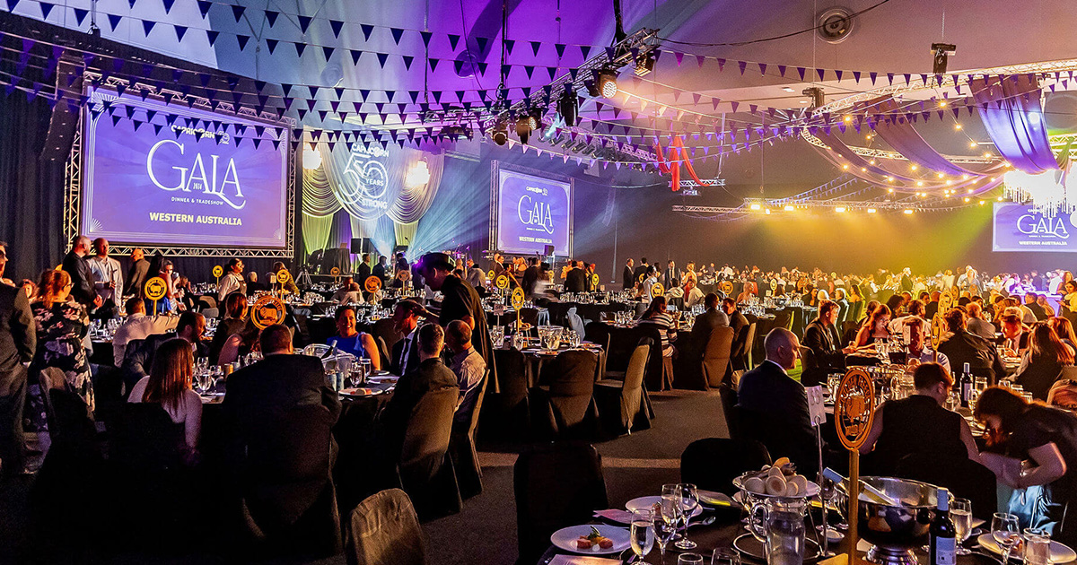 The Capricorn Gala Dinner setup in a large room, showcasing tables and chairs arranged for an elegant dining experience.